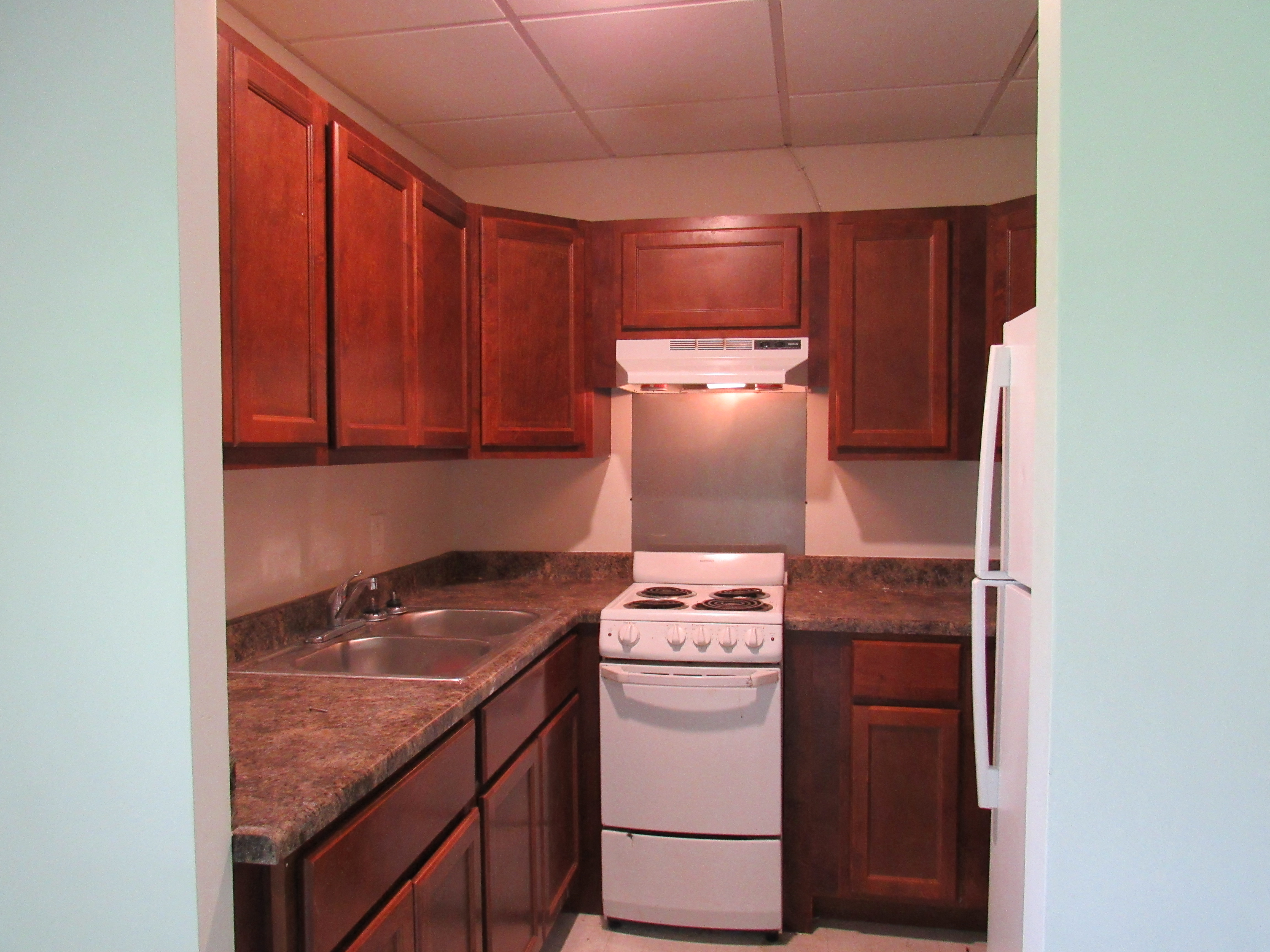 a kitchen with wooden cabinets and white appliances